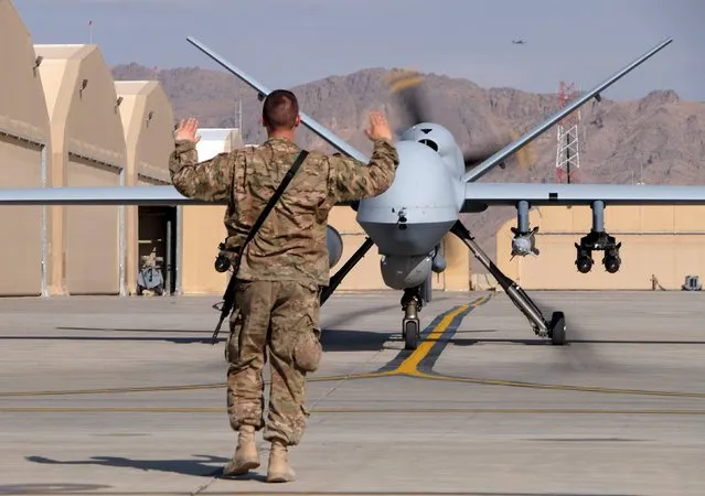 A U.S. airman guides a U.S. Air Force MQ-9 Reaper drone as it taxis to the runway at Kandahar Airfield, Afghanistan March 9, 2016. (Photo by Josh Smith/Reuters)