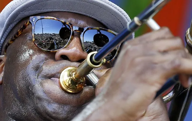 The crowd is reflected in the sunglasses of Big Sam, of Big Sam's Funky Nation, as he performs at the New Orleans Jazz and Heritage Festival in New Orleans, Saturday, April 23, 2016. (Photo by Gerald Herbert/AP Photo)