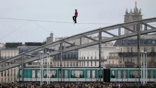 French acrobat Denis Josselin balances on a tightrope as he crosses the Seine river in front of the Austerlitz bridge in Paris, April 6, 2014. (Photo by Christian Hartmann/Reuters)