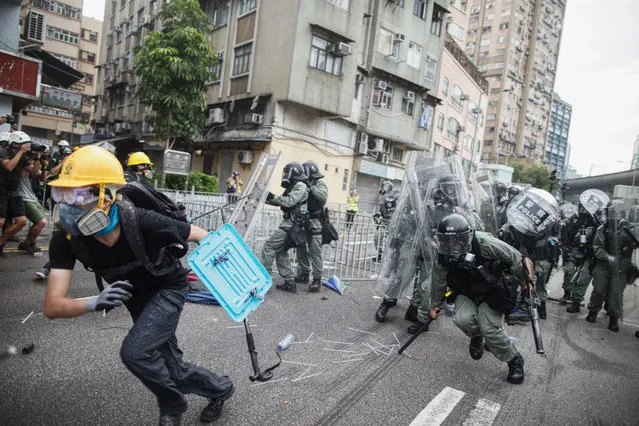 A protester flee from baton wielding police in Yuen Long district in Hong Kong on Saturday, July 27, 2019. Police in Hong Kong used tear gas against protesters Saturday who defied authorities' warnings not to march in a neighborhood where six days earlier a mob apparently targeting demonstrators brutally attacked people in a commuter rail station. (Photo by Eric Tsang /HK01 via AP Photo)