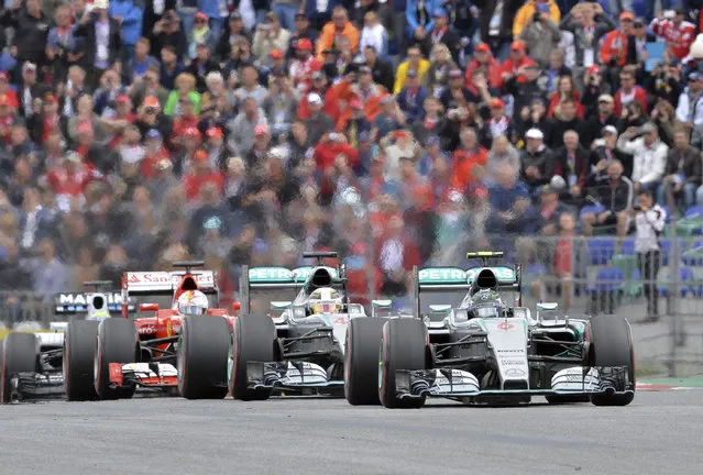 Mercedes driver Nico Rosberg, right, of Germany steers his car in front of Mercedes driver Mercedes driver Lewis Hamilton of Britain, center and Ferrari driver Sebastian Vettel of Germany during the Austrian Formula One Grand Prix race at the Red Bull Ring  in Spielberg, southern Austria, Sunday, June 21, 2015. (AP Photo/Kerstin Joensson)