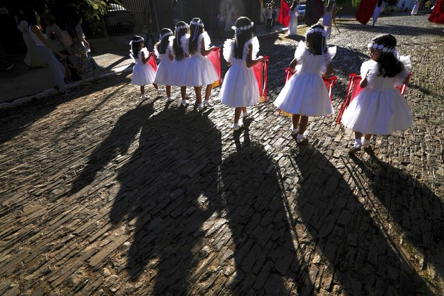 Flag girls partake in the Cavalhadas festival in Pirenopolis, Goias, Brazil, May 19, 2024. A Portuguese priest brought the tradition to Brazil in the 1800s to celebrate the Holy Spirit and to commemorate the victory of Iberian Christian knights over the Moors. (Photo by Eraldo Peres/AP Photo)