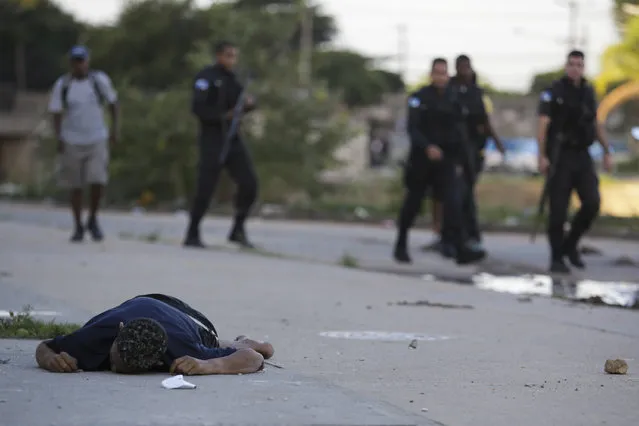 The dead of an alleged drug trafficker lays on the ground after a shooting during a police operation at Pavuna slum, in Rio de Janeiro, Brazil, Thursday, March 30, 2017.  Military police in Rio de Janeiro say they are investigating a video that appears to show two officers execute the injured suspects . During that confrontation, police say a 13-year-old girl was killed from a stray bullet. The girl was in school close by. (Photo by Diego Herculano/AP Photo)