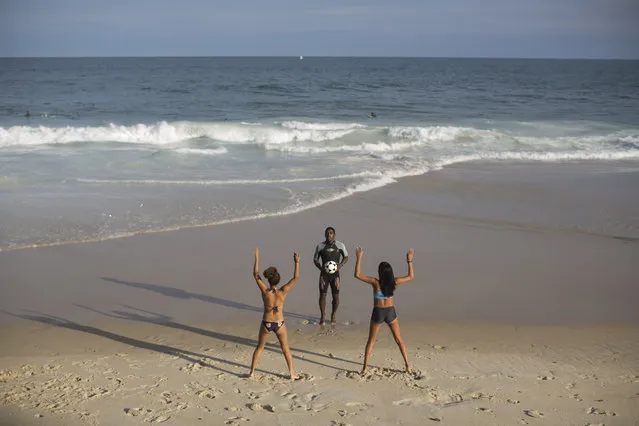 Rocinha Surf Association, ASR, teacher Carlos Belo, center, exercises young students before entering the water at Sao Conrado brach in Rio de Janeiro, Brazil, Thursday, July 2, 2015. (Photo by Felipe Dana/AP Photo)