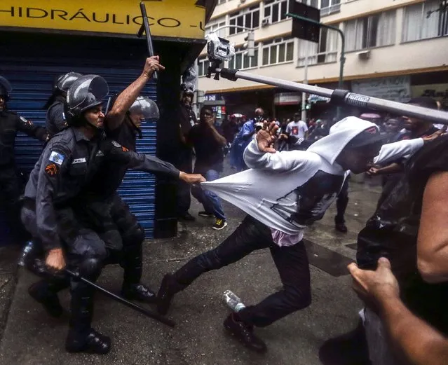 Police clash with residents from the Pavao-Pavaozinho shanty town, in the neighborhood of Copacabana, south of the city of Rio de Janeiro, Brazil, 24 April 2014. The death of a dancer in one of Rio de Janeiro's slums touched off violent protests and sparked an investigation on 24 April into the role that the militarized police might have played. (Photo by Antonio Lacerda/EPA)