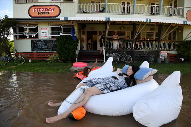 A pub worker Tahlia Thomasson and local children play in floodwaters caused by Cyclone Debbie outside the Fitzroy Hotel in Rockhampton, Australia on April 4, 2017. (Photo by Dan Peled/Reuters/AAP)
