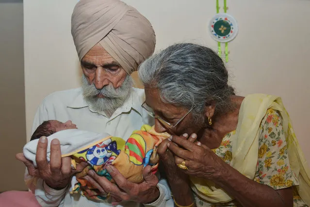 Indian father Mohinder Singh Gill, 79, and his wife Daljinder Kaur, 70, pose for a photograph as they hold their newborn baby boy Arman at their home in Amritsar on May 11, 2016. An Indian woman who gave birth at the age of 70 said May 10 she was not too old to become a first-time mother, adding that her life was now complete. Daljinder Kaur gave birth last month to a boy following two years of IVF treatment at a fertility clinic in the northern state of Haryana with her 79-year-old husband. (Photo by Narinder Nanu/AFP Photo)