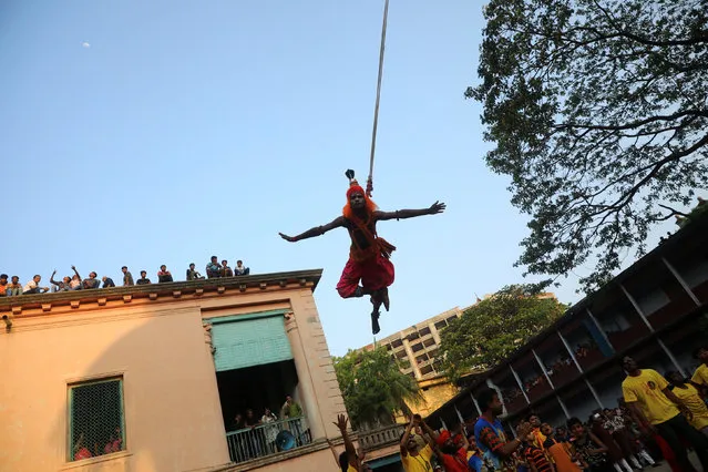 A Hindu saint hangs on an iron hook as he performs during Charak Puja, a Hindu festival in Dhaka, Bangladesh, April 14, 2019. (Photo by Mohammad Ponir Hossain/Reuters)