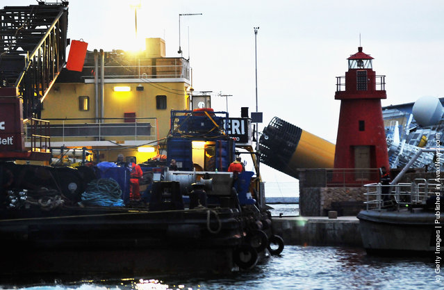Rotterdam based SMIT and Livorno based NERI salvage workers start their work of diesel recovery on a pontoon from the the cruise ship Costa Concordia that lies stricken off the shore of the island of Giglio