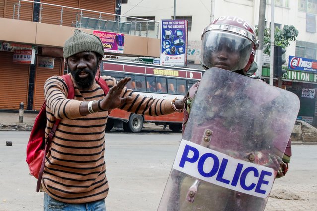 A man gestures next to a police member at a demonstration over police killings of people protesting against Kenya's proposed finance bill 2024/2025, in Nairobi, Kenya, on June 27, 2024. (Photo by Monicah Mwangi/Reuters)