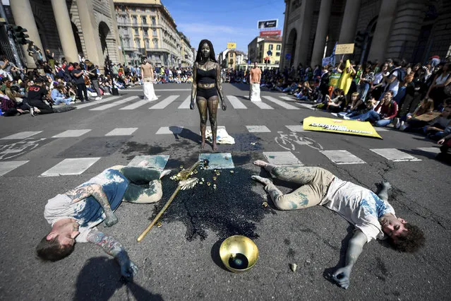 Demonstrators of the Fridays for Future movement perform in Milan, Italy, Friday, March 25, 2022. (Photo by Claudio Furlan/LaPresse via AP Photo)
