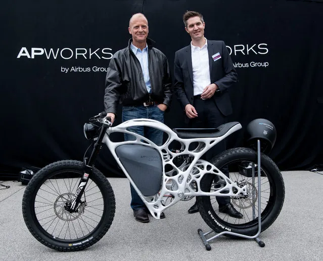 The CEO of Airbus, Tom Enders, left, and the head of APWorks, Joachim Zettler, present the first 3D printed electric motorcycle in Ottobrunn, Germany,  Friday May 20, 2016. The motorcycle was made of metal powder by using lasermelting technology. The bike only weighs 35 kilos. (Photo by Sven Hoppe/DPA via AP Photo)