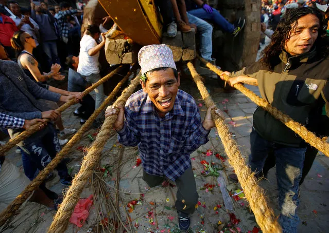 A devotee holds on to the ropes tied to the chariot of God Bhairab during the Biska Festival also known as Bisket festival in Bhaktapur, Nepal April 10, 2017. (Photo by Navesh Chitrakar/Reuters)