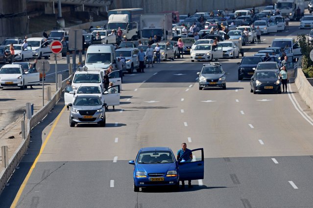 Drivers stand still in Tel Aviv on April 18, 2023 as sirens blare for two minutes marking Israel's annual Holocaust Remembrance Day in memory of the six million Jews killed during World War II. (Photo by Jack Guez/AFP Photo)