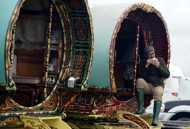A man sits in his caravan during the Appleby Horse Fair on June 5, 2014 in Appleby, England. The Appleby Horse Fair has existed under the protection of a charter granted by James II since 1685 and is one of the key gathering points for the Romany, gypsy and traveling community. The fair is attended by about 5,000 travellers who come to buy and sell horses. The animals are washed and groomed before being ridden at high speed along the “mad mile” for the viewing of potential buyers. (Photo by Nigel Roddis/Getty Images)
