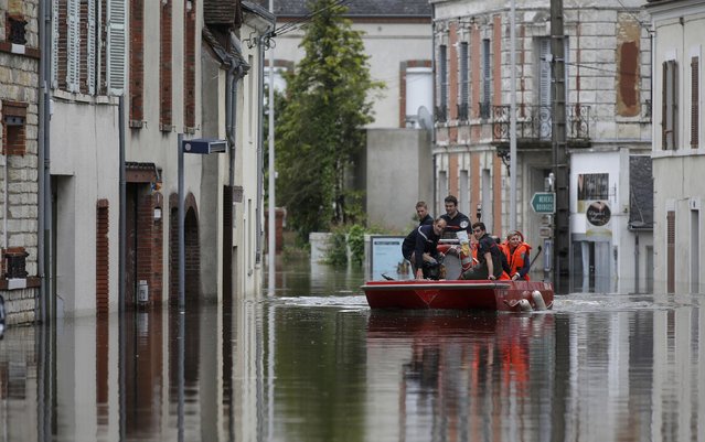 French firefighters on a small boat evacuate residents from a flooded area after heavy rain falls in Montargis, near Orleans, France, June 1, 2016. (Photo by Christian Hartmann/Reuters)