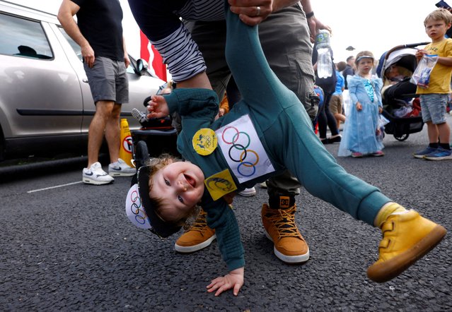 Brodie White, 1, dressed as the Australian Olympic breakdancer Rachael Gunn, known by her competition name Raygun who participated in the sport of Breaking, is held by his dad at a children's fancy dress parade at the Cruinniu na mBad (gathering of the boats) regatta in Kinvara, Ireland on August 18, 2024. (Photo by Clodagh Kilcoyne/Reuters)