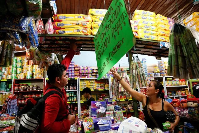 A woman tries to reach a package of nappies at a store in Puerto Santander, Colombia, June 3, 2016. (Photo by Carlos Garcia Rawlins/Reuters)