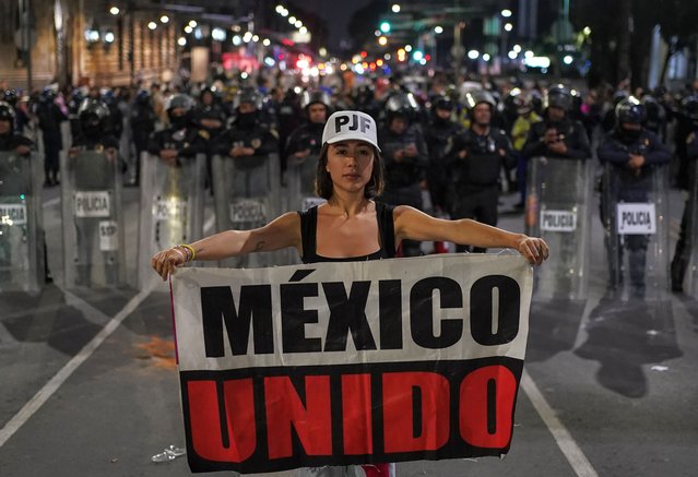 Student Daniela Camberos holds a banner that reads in Spanish “Mexico United” in front of police during a protest against the government's proposed judicial reform, which would make judges stand for election, outside the Senate in Mexico City, Tuesday, September 10, 2024. (Photo by Felix Marquez/AP Photo)