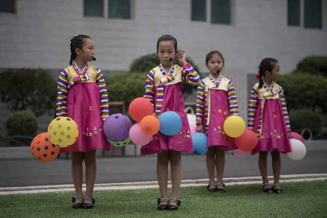 Children prepare to perform a dance routine as part of activities marking “Children' s Union Foundation day”, in Pyongyang on June 6, 2017. (Photo by Ed Jones/AFP Photo)