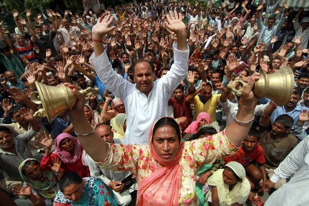 Indian protesters ring bell and shout slogans during protest demonstration in Jammu, the winter capital of Kashmir, India, 15 June 2016. According to the news reports, mobile internet services were suspended in all 10 districts of Jammu region after the protests against the desecration of an ancient temple of Lord Shiva by youth of the other community whom was blamed for smashing the window panes and doors of a temple. (Photo by Jaipal Singh/EPA)