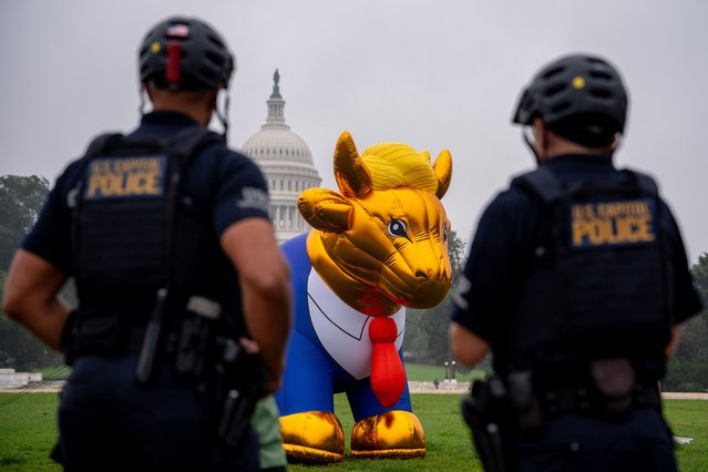 The Dome of the U.S. Capitol Building is visible Capitol Hill police officers look at a 15-foot golden calf balloon meant to resemble Republican presidential candidate former President Donald Trump on the National Mall on October 2, 2024 in Washington, DC. The organization Faithful America is planning a “Christians Against Trump” protest of Trump's candidacy and a Family Research Council “Pray Vote Stand Summit” this week. (Photo by Andrew Harnik/Getty Images)