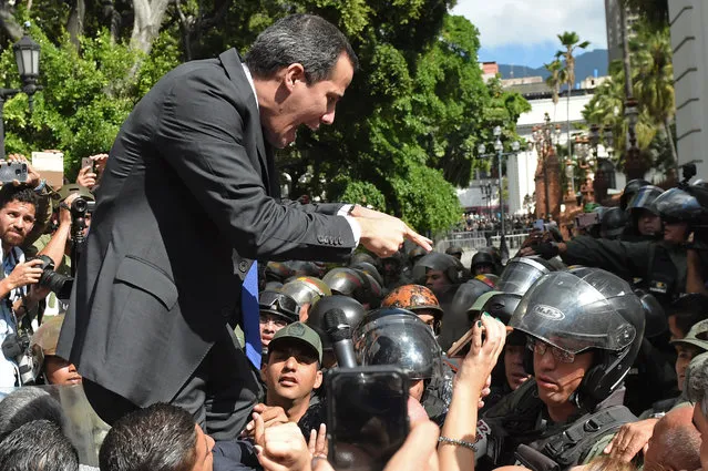 Venezuelan opposition leader and self-proclaimed acting president Juan Guaido confronts Bolivarian National Guard members upon arrival at the National Assembly, in Caracas, on January 7, 2020. Opposition leader Juan Guaido and a rival lawmaker, Luis Parra – who both had claimed to be Venezuela's parliament speaker, following two separate votes and accusations of a parliamentary coup – called for a parliamentary session today. (Photo by Cristian Hernandez/AFP Photo)