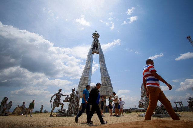 People visit the new 50-meter steel statue of Our Lady of Aparecida, national patroness of Brazil, designed by artist Gilmar Pinna in Aparecida, Sao Paulo State, Brazil, on October 12, 2024. (Photo by Miguel Schincariol/AFP Photo)