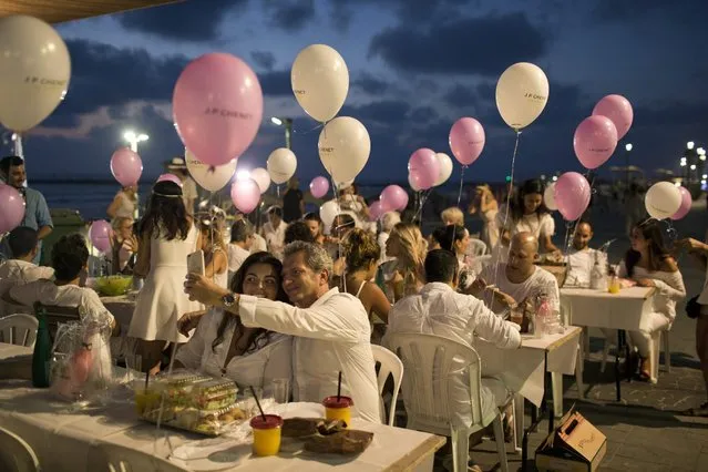 People dressed in white participate in the “Tel Aviv White Dinner” near the beach in Tel Aviv, Israel, 29 June 2016, during the opening of the Tel Aviv White Night Festival events. (Photo by Abir Sultan/EPA)