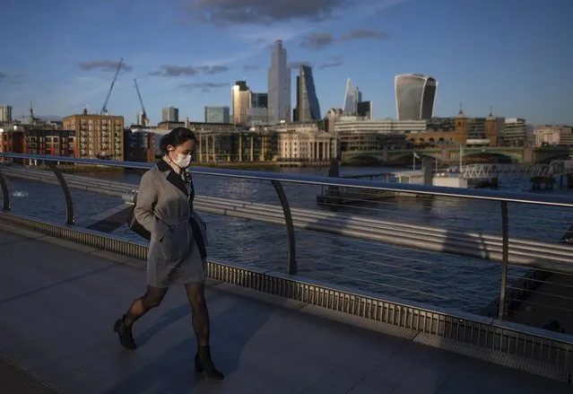 A woman crosses the millennium bridge wearing a face mask for protection against the corona virus on March 16, 2020 in London, England. The UK's coronavirus death toll rose to 35 with a total of 1,372 positive tests for coronavirus in the UK as of 9am on Sunday. (Photo by Justin Setterfield/Getty Images)