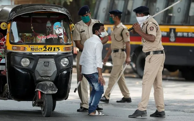 A policeman wields his baton at an autorickshaw rider as punishment for breaking the lockdown rules, after India ordered a 21-day nationwide lockdown to limit the spreading of coronavirus disease (COVID-19) in Mumbai, India on March 25, 2020. (Photo by Francis Mascarenhas/Reuters)