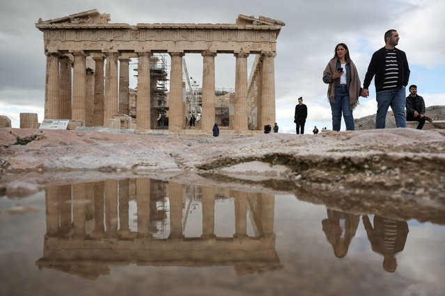 The Parthenon temple is reflected in a puddle, while people visit the Ancient Acropolis archaeological site in Athens, Greece on December 3, 2024. (Photo by Louisa Gouliamaki/Reuters)
