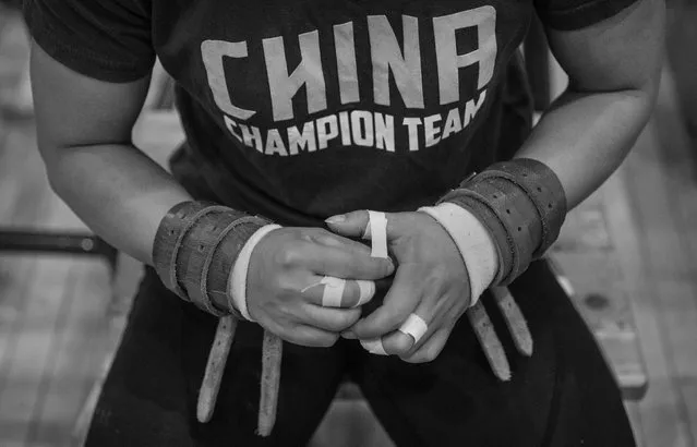 A female member of China's national weightlifting team tapes her hands before lifting during a training session in preparation for the Rio Olympics at the Training Center of General Administration of Sports in China on July 15, 2016 in Beijing, China. (Photo by Kevin Frayer/Getty Images)
