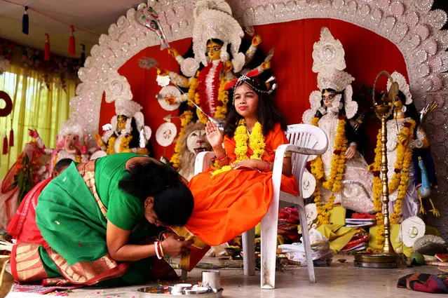 A woman worships a girl dressed as a Kumari as part of a ritual during the Durga Puja festival at a temple in Ajmer, September 29, 2017. (Photo by Himanshu Sharma/Reuters)
