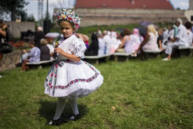 A small girl wears traditional folk dress during a Paloc festival honouring St. Anna, the patron saint of the Paloc, a group of Hungarian ethnicity with their own traditions, folk art and dialect living in a region in northern Hungary, in Balassagyarmat, 80 kms north of Budapest, 31 July 2016. (Photo by Peter Komka/EPA)