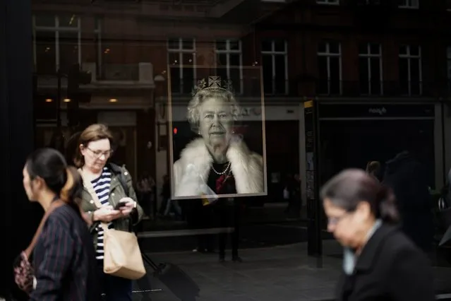 A portrait of the late Queen Elizabeth II is on display in a London shop, England, Tuesday, September 13, 2022. Queen Elizabeth II, Britain's longest-reigning monarch and a rock of stability across much of a turbulent century, died Thursday Sept. 8, 2022, after 70 years on the throne. She was 96. (Photo by Christophe Ena/AP Photo)
