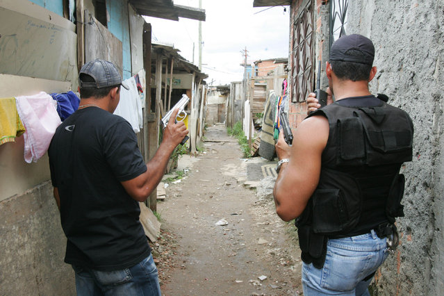 Members of the “militia” guard the streets in Rio de Janeiro, January 5, 2007. Militia, new, illegal security forces are mushrooming across Rio and are made up of active and former police, private security guards and off-duty firefighters and prison guards. (Photo by Wilton Junior/Agencia Estado via AP Photo)