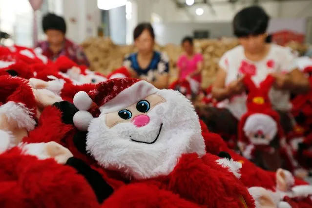 This photo taken on August 10, 2016 shows Chinese workers making Santa Claus dolls at a toy factory in Ganyu district in Lianyungang, east China's Jiangsu province. China's retail sales growth slowed sharply in July, government statistics showed on August 12, missing expectations in a disappointing sign for the world's second-largest economy as authorities look to consumer demand to push growth. (Photo by AFP Photo/Stringer)