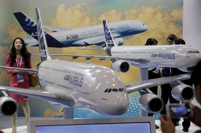 A visitor stands next to models of Airbus A380 and A330 at the Aviation Expo China 2015, in Beijing, China, September 16, 2015. (Photo by Jason Lee/Reuters)