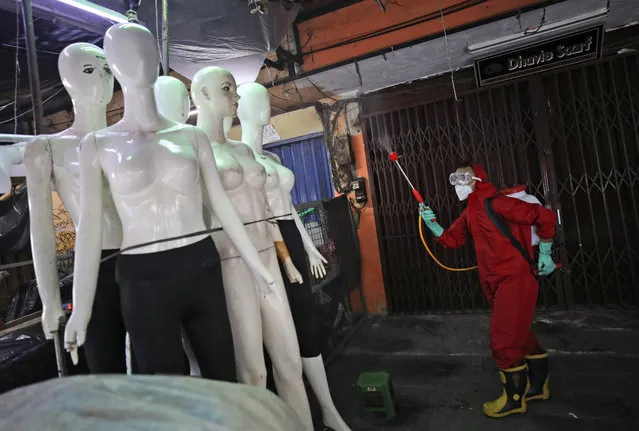 A fireman sprays disinfectant at mannequins as a precaution against coronavirus outbreak, at Tanah Abang textile market in Jakarta, Indonesia, Thursday, June 4, 2020. Authorities in Indonesia's capital will ease a partial lockdown as the world's fourth most populous nation braces to gradually reopen its economy. (Photo by Dita Alangkara/AP Photo)