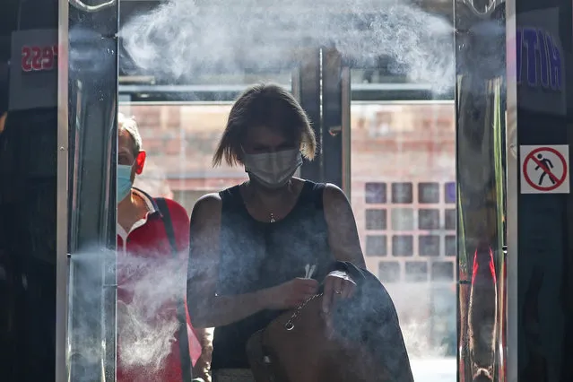 A girl walks through a disinfection gate at the entrance to the Depo (Depot) food mall in Moscow, Russia on June 16, 2020. On June 16, summer terraces started opening at Moscow cafes and restaurants. (Photo by Anton Novoderezhkin/TASS)