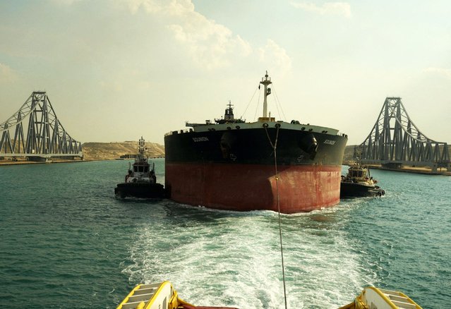 A handout picture released by the Suez Canal Authority on March 10, 2025, shows tugboats pulling Greek tanker Sounion across Egypt's Suez Canal waterway. The Greek tanker set ablaze by Yemeni rebels with more than a million barrels of oil aboard has been safely towed through the Suez Canal, the waterway's authority said on March 10. The Sounion was attacked in the Red Sea last August by Yemen's Huthi rebels, catching fire and losing power before its 25-member crew were rescued by a French frigate. (Photo by Suez Canal Authority/AFP Photo)
