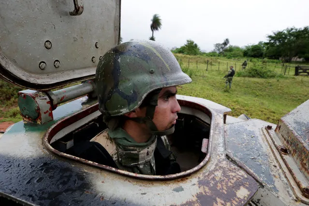 A soldier looks out of an armoured personnel carrier as he and fellow soldiers patrol the area near the place where eight soldiers were killed days ago during an ambush that authorities say bore the hallmarks of the guerrilla group known as the Paraguayan People's Army in Arroyito, Paraguay, August 29, 2016. (Photo by Jorge Adorno/Reuters)