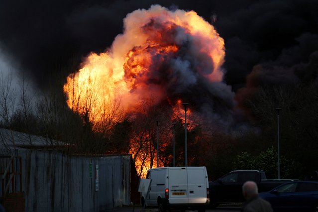 Members of the public look on as a fireball rises from the scene of a large fire on an industrial estate in Manchester, Britain, on February 23, 2025. (Photo by Phil Noble/Reuters)
