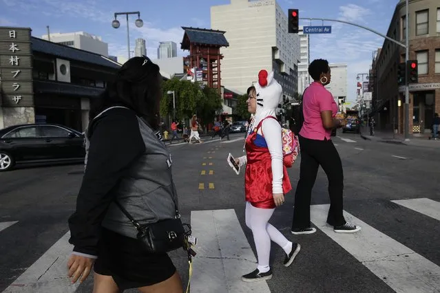Wearing a Hello Kitty costume, Brandee Amore, center, of Glendale, Calif., walks across the street before the start of the Hello Kitty Con, the first-ever Hello Kitty fan convention, held at the Geffen Contemporary at MOCA Thursday, October 30, 2014, in Los Angeles. (Photo by Jae C. Hong/AP Photo)