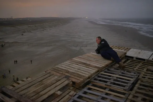 Inhabitants of Duindorp, a fishing neighborhood in The Hague, build a thirty five meter high bonfire on the beach in The Hague on December 30, 2017. Tens of thousands of wooden pallets collected during the year and stored in secret locations are lifted and piled up until the evening of December 31. The New Year's Eve bonfire of Duindorp has been relocated on the beach in the nineties to restore peace in the neighborhood as violent brawls often erupted and many vehicles were set on fire. (Photo by Pierre Crom/Getty Images)