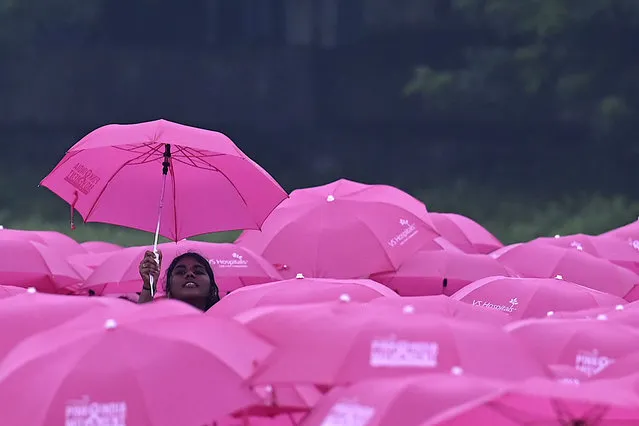 College students hold umbrellas to make a formation of pink ribbon during a breast cancer awareness campaign in Chennai, India on October 31, 2022. (Photo by Arun Sankar/AFP Photo)