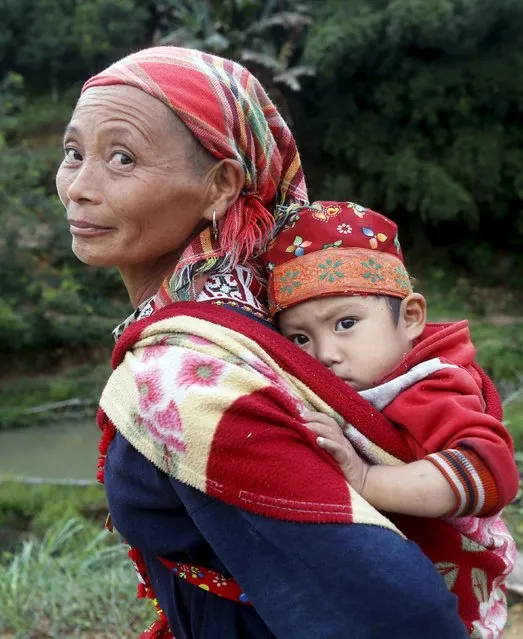 A woman of the Dao ethnic tribal carries her grandson on her back while walking along a road in Hoang Su Phi, north of Hanoi, Vietnam September 18, 2015. (Photo by Reuters/Kham)