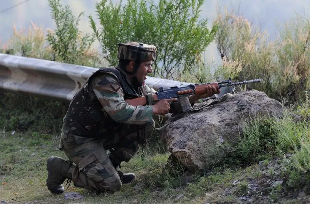 An Indian army soldier takes up a position near the site of a gunbattle between Indian army soldiers and rebels inside an army brigade headquarters near the border with Pakistan, known as the Line of Control (LoC), in Uri on September 18, 2016. Militants armed with guns and grenades killed 17 soldiers in a raid September 18 on an army base in Indian-administered Kashmir, the worst such attack for more than a decade in the disputed Himalayan region. (Photo by Tauseef Mustafa/AFP Photo)
