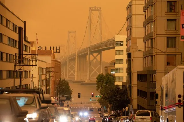 The Bay Bridge is seen under an orange sky darkened by the smoke from California wildfires in San Francisco, California, U.S., September 9, 2020. (Photo by Stephen Lam/Reuters)